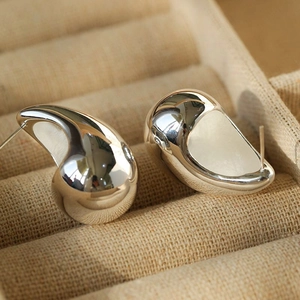 Chic 18K silver metal teardrop earrings displayed in a beige jewelry box