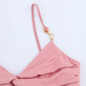 Close-up of pink linen shoulder strap with gold buckle and pink gemstone detail