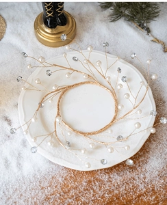 Close-up of a gold wire Christmas wreath ornament with white pearls and sparkling crystals