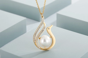 Macro detail of gold-plated stainless steel pendant with pearl and sparkling crystals