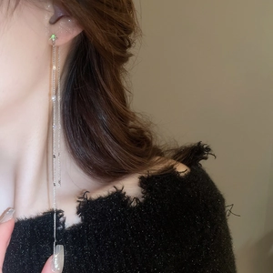 Detail of silver long tassel earrings with sparkling cubic zirconia on a model side profile