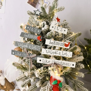 Grey and white wooden Christmas tree hanging signs with bells and plaid bows decor