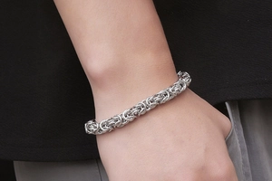Close-up of Byzantine weave stainless steel bracelet worn on a male wrist for style