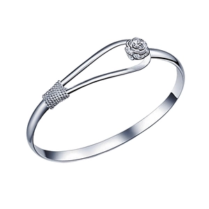 Close-up of a silver metal cuff bracelet featuring an intricate rose flower and woven texture