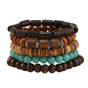 Detail of five stacked men's handmade beaded bracelets with wood and turquoise stone beads