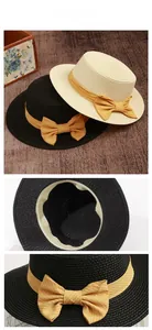 Detail of flat top straw boater hats showing weaving texture and striped bow ribbons