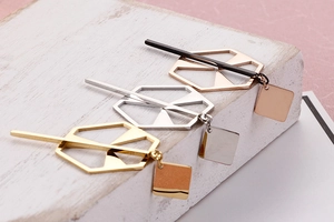 Detail view of geometric hollow earrings in gold, silver and rose gold finishes
