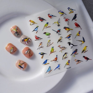 Close-up of 5D embossed bird nail stickers with colorful hummingbird and magpie designs