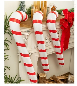 Detail of red and white inflatable candy canes in a cozy fireplace Christmas setting