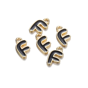 Detail of five golden letter F charms with black enamel finish and hanging loops
