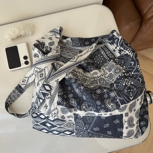 Flat lay detail of a bohemian paisley printed linen tote bag with wide shoulder strap