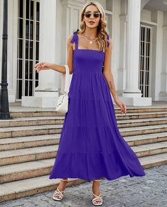Detail view of purple smocked bodice and tiered maxi dress on a model outdoors