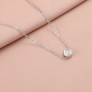 Detail of silver stainless steel necklace featuring a textured spiral snail shell pendant
