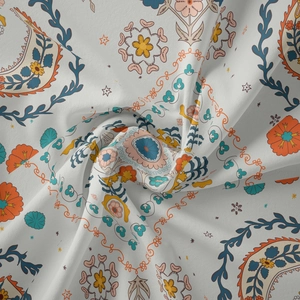 Close-up of mandala tapestry fabric with orange and blue paisley patterns and soft texture