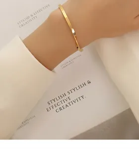 Close-up of twisted 18k gold plated stainless steel cuff bracelet on woman's wrist