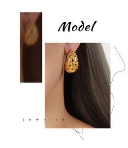 Macro shot of gold teardrop earrings featuring a detailed woven texture and polished finish