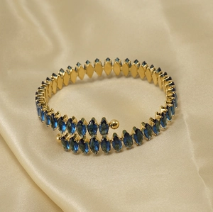 Detail of 18K gold-plated spiral bangle featuring marquise-cut navy blue zircons