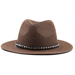 Close-up of brown straw cowboy hat with black leather band and silver square rivets
