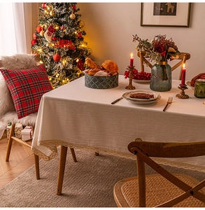 Close-up of beige rectangular tablecloth with lace edges in a festive Christmas setting