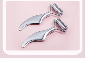 Detail of silver stainless steel facial massage rollers with textured spiked heads