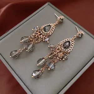 Bohemian vintage flower tassel earrings with crystals and grey stones on a jewelry box