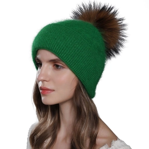 Green Angora rabbit hair knitted beanie with large raccoon fur pom-pom for winter warmth