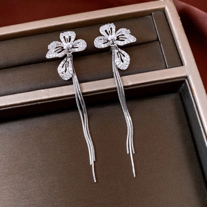 Macro shot of silver tassel earrings with zircon flower petals and hanging metal fringe