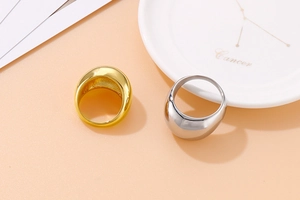 Macro shot of chunky gold and silver dome rings in high-polish stainless steel