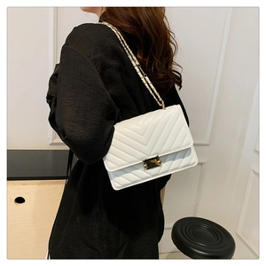 Detailed side view of a white V-quilted faux leather shoulder bag with gold chain strap