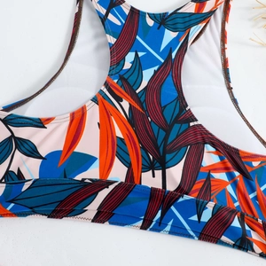 Detail of tropical leaf print bikini top featuring blue and orange patterns with mesh lining