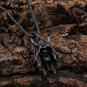 Gothic style Hannya demon mask pendant in vintage silver finish on wood bark background