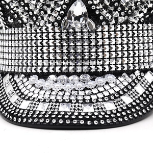 Close-up of sparkling silver rhinestones and white pearls on a black punk party hat