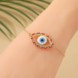 Gold evil eye bracelet with blue pendants and clear crystals on a female wrist