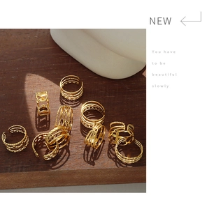 Detalle de anillos geométricos apilados de acero de titanio chapado en oro de 18 quilates