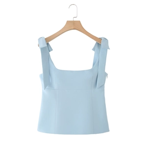 Sky blue sleeveless camisole top with decorative bow straps on a wooden hanger