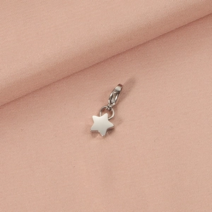 Detailed view of a silver stainless steel star pendant with a spring clasp on fabric