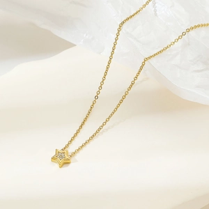 Elegant gold star pendant necklace with small sparkling zircon on wave textured base