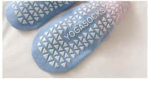 Dettaglio dei motivi in silicone antiscivolo sulle calze da yoga sfumate blu e rosa