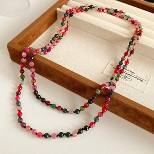 Close-up of faceted multi-color tourmaline beaded necklace on a brown velvet tray