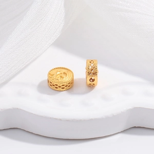 Macro shot of gold hollow-out floral spacer beads for DIY jewelry making with relief pattern