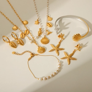 Golden ocean jewelry set featuring starfish pendants, shell charms and pearl necklace