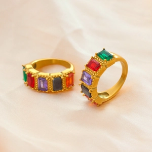 Minimalist gold-plated eternity rings with colorful rectangular gemstones on beige silk
