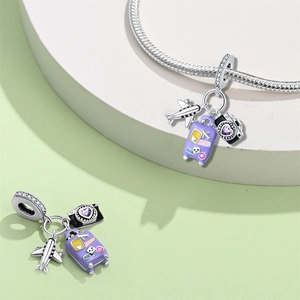 Detail view of 925 silver travel charms featuring a purple suitcase and camera with stones