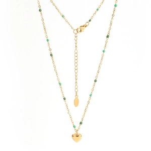 Détail d'un collier en acier inoxydable doré avec perles vertes et pendentif cœur