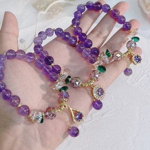 Detailed shot of amethyst bracelets with gold pendants and zircon flower accents