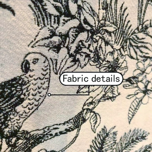 Detailed macro view of Toile de Jouy fabric with floral and parrot patterns on a tote bag