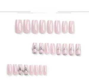 Close-up of glitter pink press-on nails with 3D rhinestones and glossy finish details
