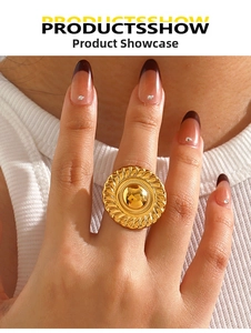 Detail of chunky gold geometric disc ring with radial woven texture and polished dome center