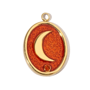 Detailed macro view of golden oval pendant featuring crescent moon and orange gemstone