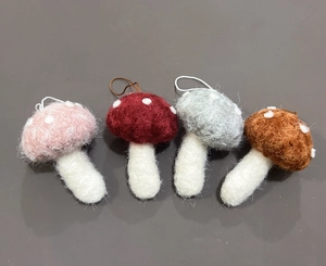 Dettaglio di funghi in feltro di lana in quattro colori con cordini pendenti